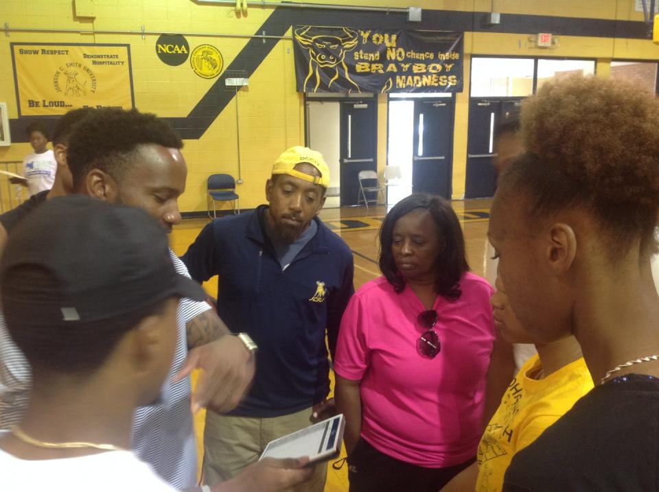 Coaches and basketball players huddle around each other.