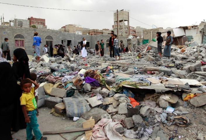Yemenis stand amid the ruins of buildings destroyed in an air-strike by the Saudi-led coalition on the capital Sanaa on July 13, 2015 (AFP Photo/Mohammed Huwais)