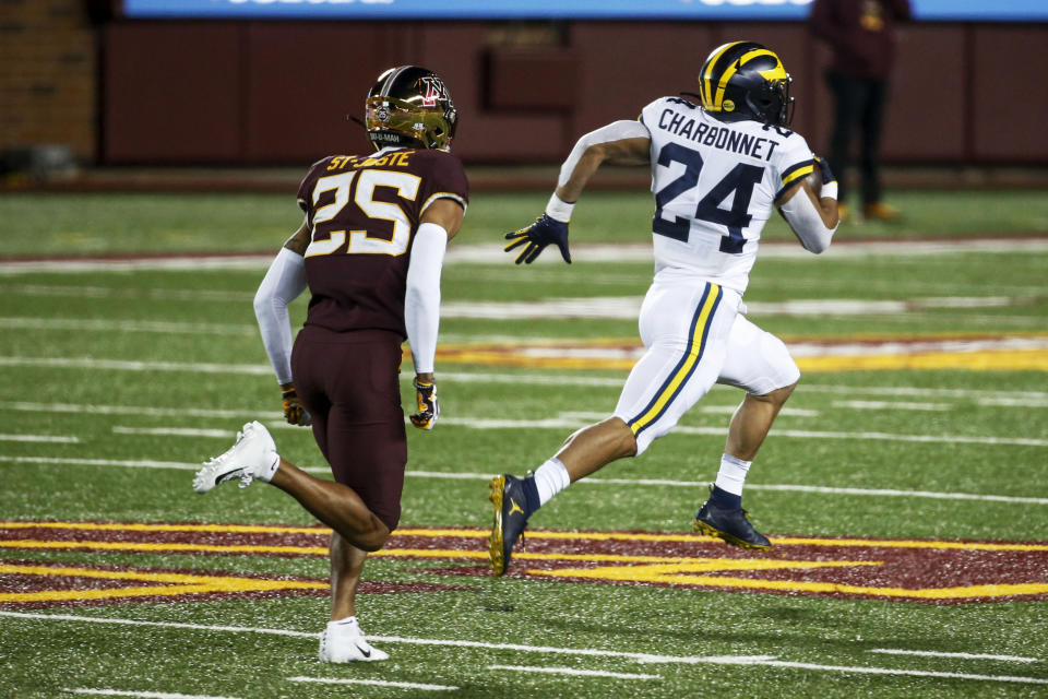 Michigan running back Zach Charbonnet (24) breaks away from Minnesota defensive back Benjamin St-Juste (25) for a 70 yard touchdown run in the first quarter of an NCAA college football game Saturday, Oct. 24, 2020, in Minneapolis. (AP Photo/Bruce Kluckhohn)