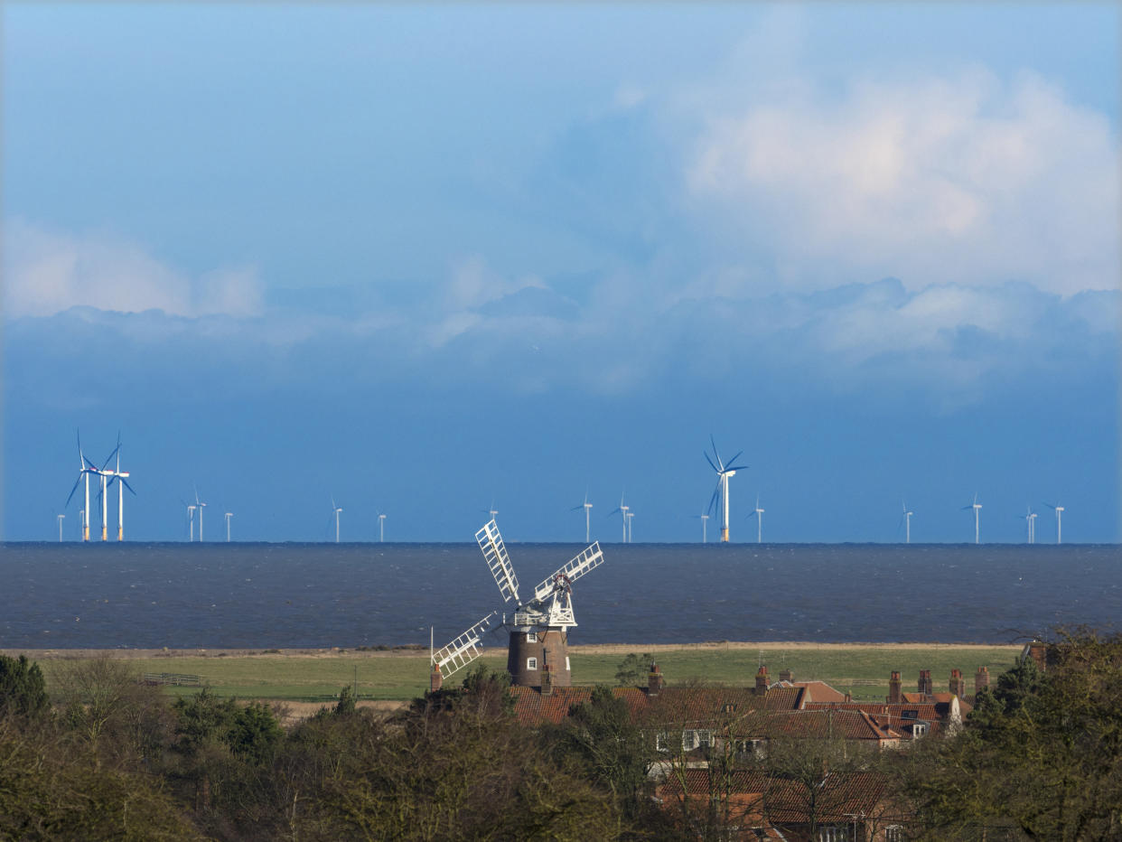 Cley windmill with the Sheringham shoal wind-farm in the distance. (Photo by: Gary Smith/Loop Images/Universal Images Group via Getty Images)