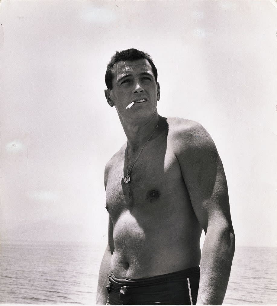 <p>Rock Hudson smokes a cigarette on the beach in 1940.</p>