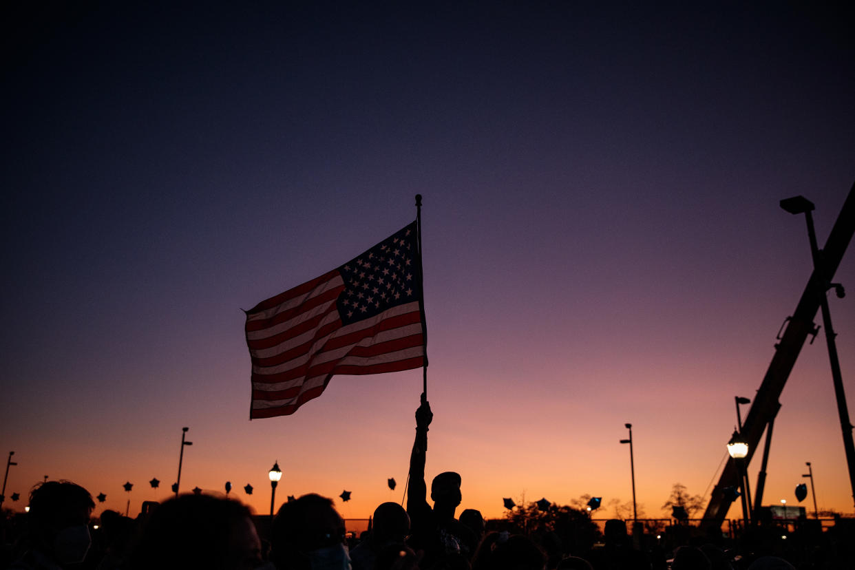 Un partidario del presidente electo Joe Biden alza la bandera en un mitin en Wilmington, Delaware, el sábado 7 de octubre de 2020. (Damon Winter/The New York Times)