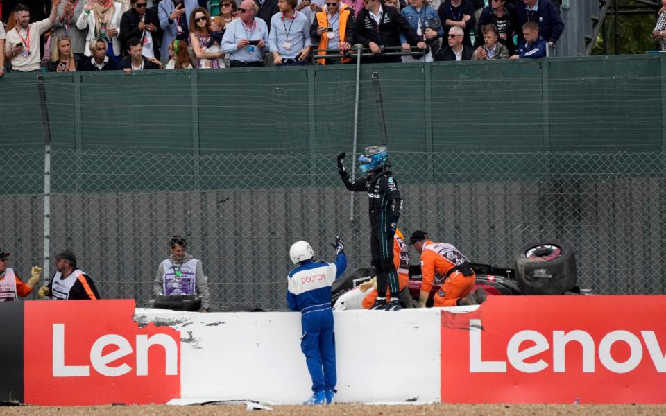 British Grand Prix - Silverstone Circuit, Silverstone, Britain - July 3, 2022 Alfa Romeo's Guanyu Zhou is stuck in the car as Mercedes' George Russell looks on after they crashed out at the start of the race - Pool via REUTERS 