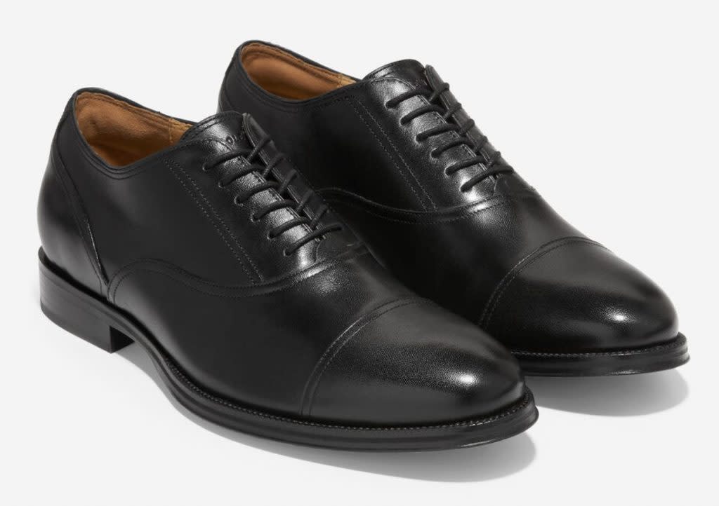 Black cap-toe oxford shoes with single stitch at toe.