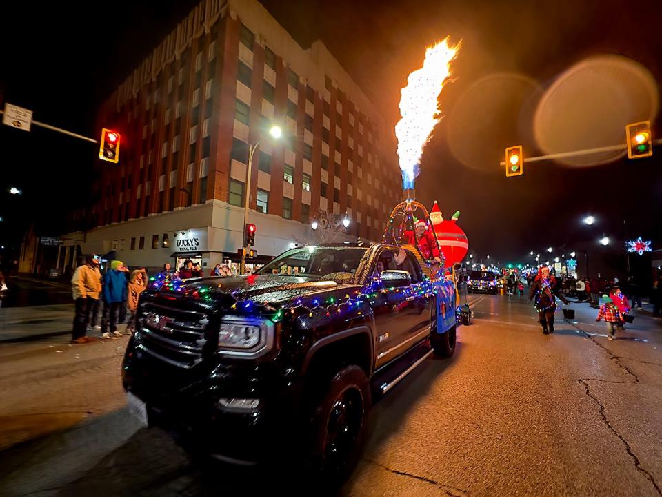 Greg Saul of Galesburg shoots flames from the basket of his hot air balloon as he rides in a float during the Galesburg Downtown Community Partnership Holly Days Parade on Sunday. For more photos and video, visit galesburg.com.