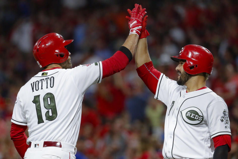 Cincinnati Reds' Joey Votto (19) celebrates with Eugenio Suarez (7) after hitting a solo home run off Chicago Cubs starting pitcher Yu Darvish in the sixth inning of a baseball game, Friday, Aug. 9, 2019, in Cincinnati. (AP Photo/John Minchillo)