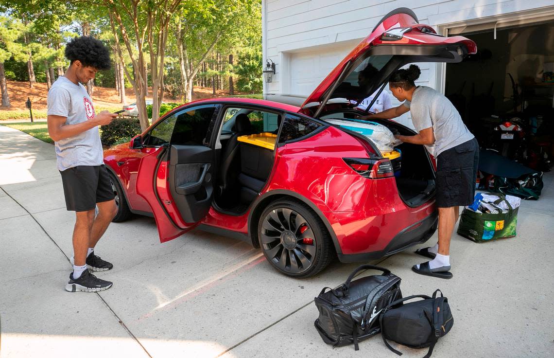 Jarin Stevenson check his phone as his parents Jarod and Nicole Stevenson help their son load his car for the trip to Tuscaloosa, Ala., on Wednesday, June 28, 2023 at their home in Chapel Hill, N.C. Stevenson will enroll in summer classes and begin training for the Crimson Tide’s 2023-24 basketball season. One week ago Stevenson, one of the top high school basketball players in North Carolina announced he was reclassifying, and committed to play for the University of Alabama. 