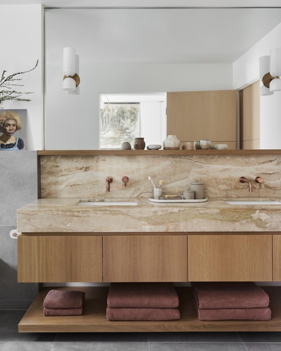 A bathroom with brass accents and wooden detail