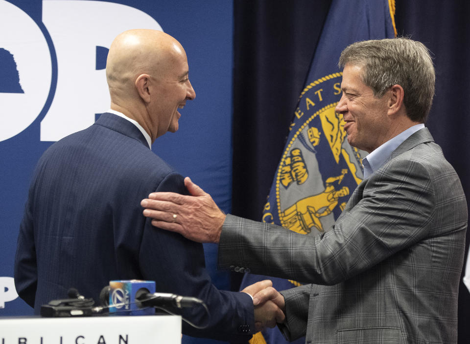 Gov. Pete Ricketts, left, shakes hands with Jim Pillen, Republican candidate for governor, during the Nebraska Republican Party general election kickoff at the Republican state headquarters., Wednesday, May 11, 2022, in Lincoln, Neb. (Gwyneth Roberts/Lincoln Journal Star via AP)