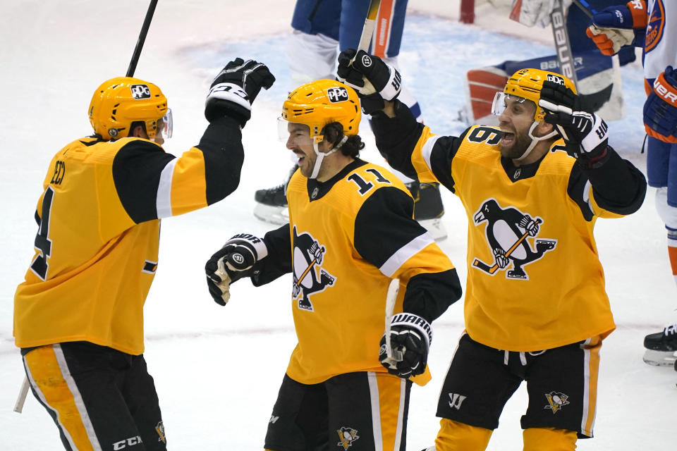 Pittsburgh Penguins' Frederick Gaudreau (11) celebrates his goal with Cody Ceci, left, and Jason Zucker during the first period of Game 1 of an NHL hockey Stanley Cup first-round playoff series against the New York Islanders in Pittsburgh, Sunday, May 16, 2021. (AP Photo/Gene J. Puskar)