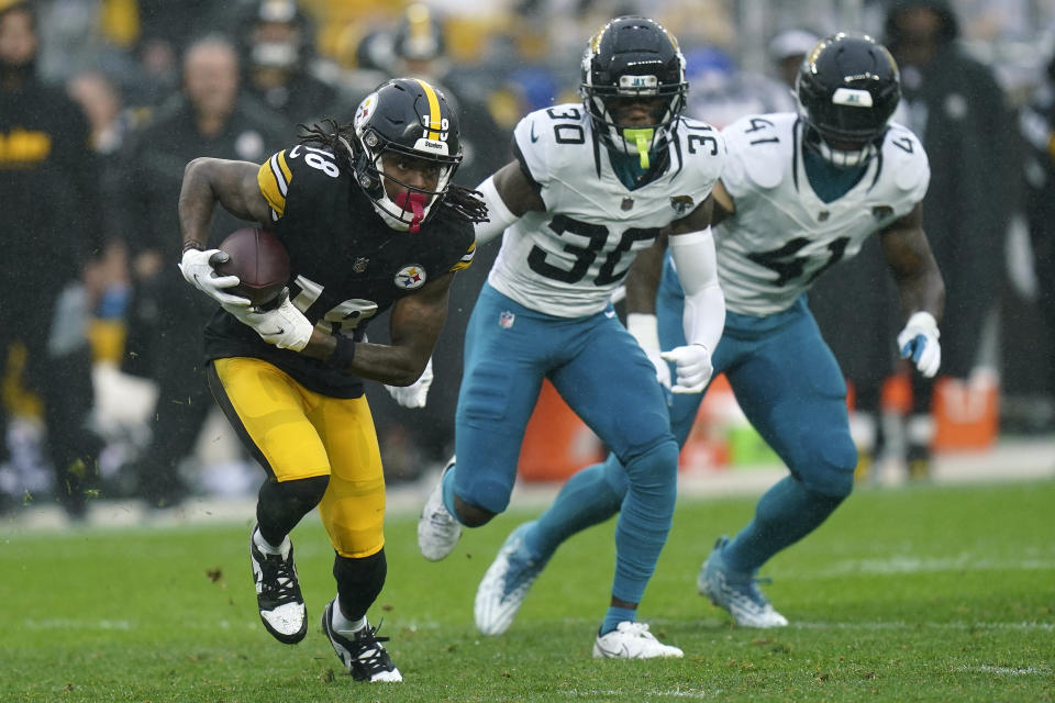 Pittsburgh Steelers wide receiver Diontae Johnson (18) eludes Jacksonville Jaguars cornerback Montaric Brown (30) and linebacker Josh Allen (41) after a catch during the first half of an NFL football game Sunday, Oct. 29, 2023, in Pittsburgh. (AP Photo/Matt Freed)