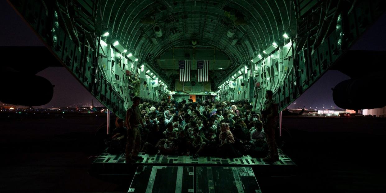 Evacuees on a military cargo plane at night