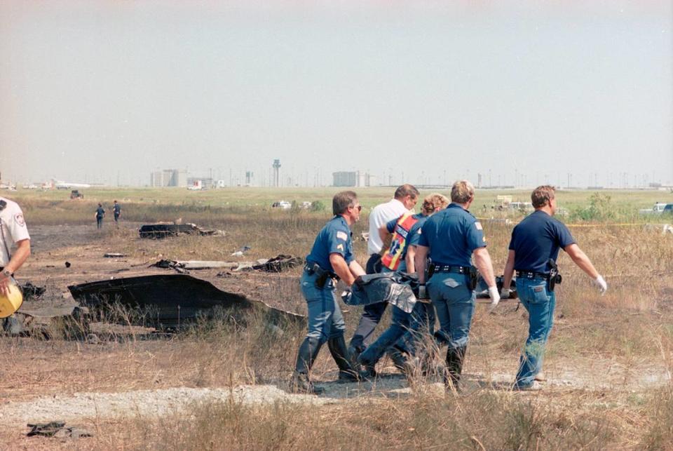 Aug. 31, 1988: Emergency responders carry a victim of Delta 1141 to a temporary morgue set up on site at Dallas-Fort Worth International Airport.