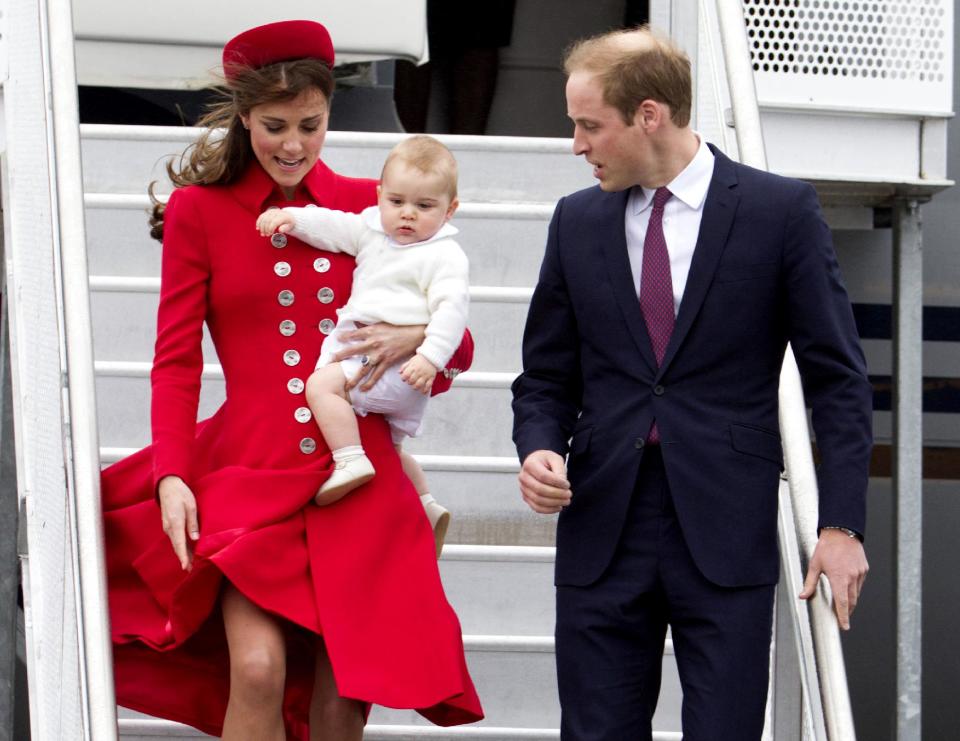 Kate, 32, struggled to keep her dress and pill-box hat under control in blustery conditions as she carried her baby down the steps of the New Zealand Air Force 757 to be greeted by Prime Minister John Key. (AP Photo/SNPA, David Rowland) NEW ZEALAND OUT