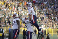 New England Patriots quarterback Bailey Zappe, right, celebrates with teammate David Andrews after throwing a 25-yard touchdown pass during the second half of an NFL football game against the Green Bay Packers, Sunday, Oct. 2, 2022, in Green Bay, Wis. (AP Photo/Matt Ludtke)