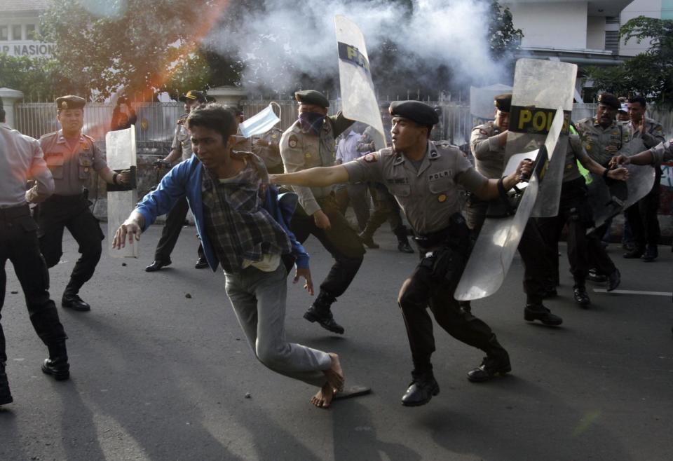 Indonesian police officers try to catch a student during a protest against price hikes on fuel, in Jakarta, Indonesia, Wednesday, March 14, 2012 .(AP Photo/Achmad Ibrahim)