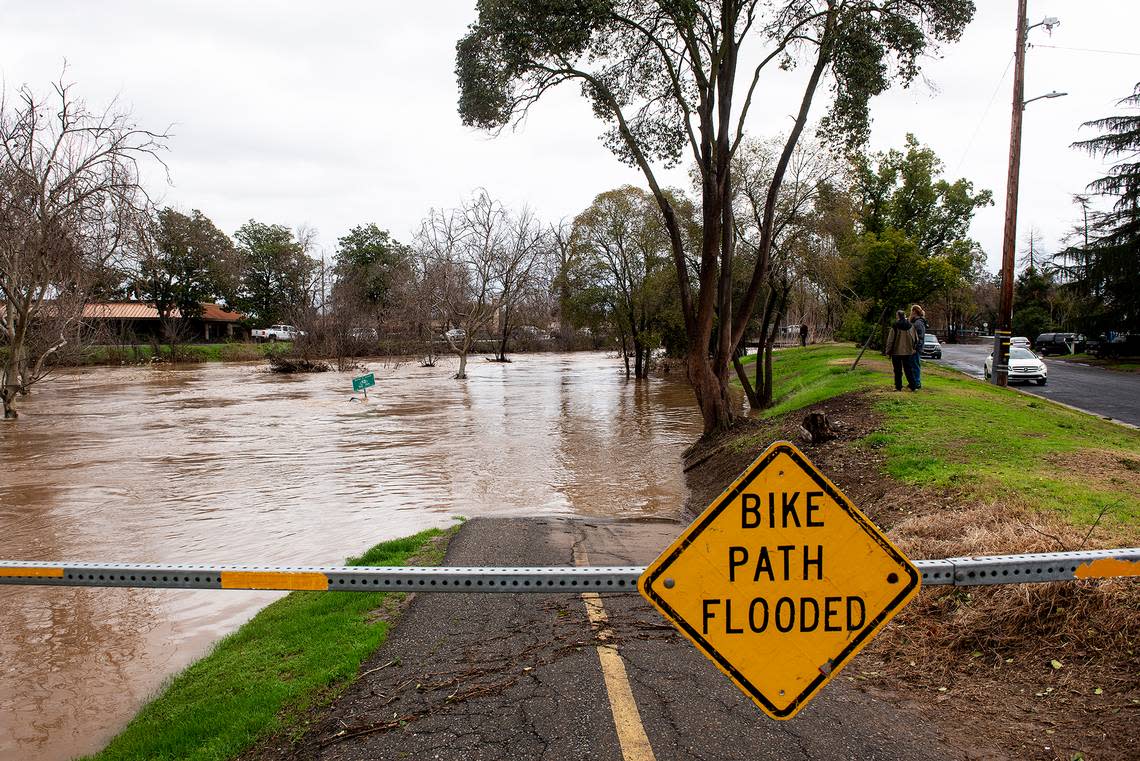 Bear Creek flows past G Street flooding the Michael O. Sullivan bike path and the surrounding area in Merced, Calif, on Tuesday, Jan. 10, 2023.