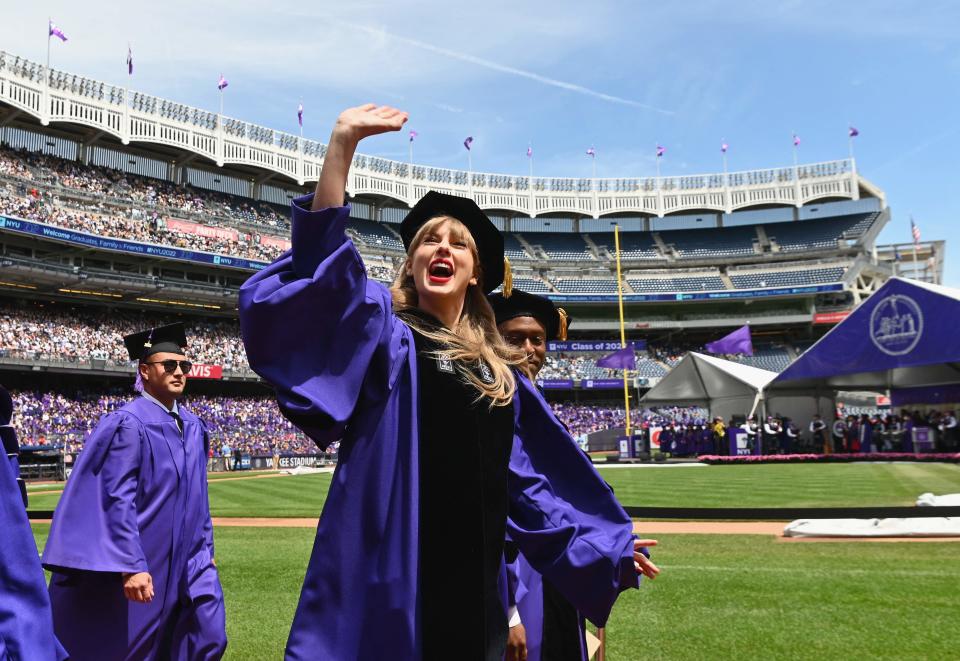 Singer Taylor Swift waves at graduating students during New York University's commencement ceremony for the class of 2022.