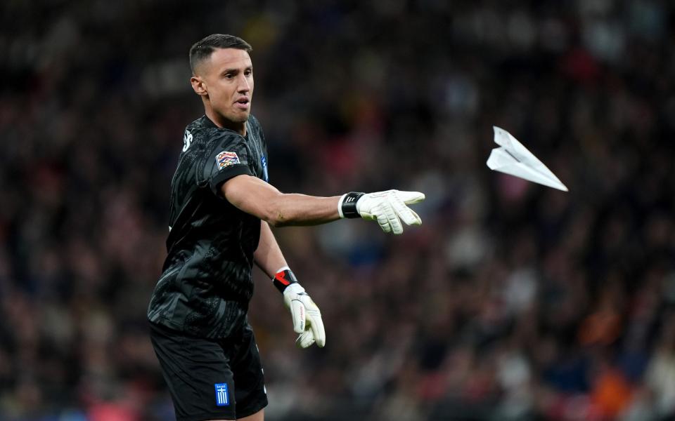 Greece goalkeeper Odisseas Vlachodimos throws away a paper aeroplane