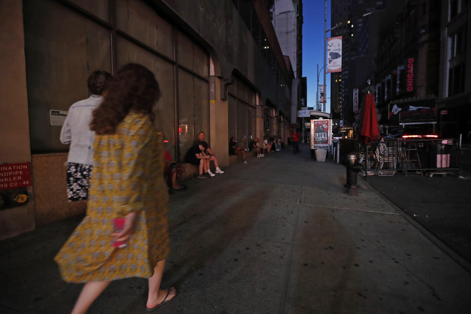 People walk in midtown Manhattan during a widespread power outage, Saturday, July 13, 2019, in New York. Authorities were scrambling to restore electricity to Manhattan following a power outage that knocked out Times Square's towering electronic screens, darkened marquees in the theater district and left businesses without electricity, elevators stuck and subway cars stalled. (AP Photo/Michael Owens)