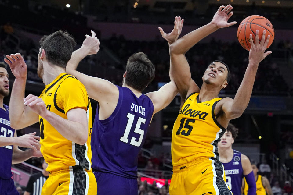 Iowa forward Keegan Murray (15) grabs a rebound over Northwestern center Ryan Young (15) in the first half of an NCAA college basketball game at the Big Ten Conference tournament in Indianapolis, Thursday, March 10, 2022. (AP Photo/Michael Conroy)