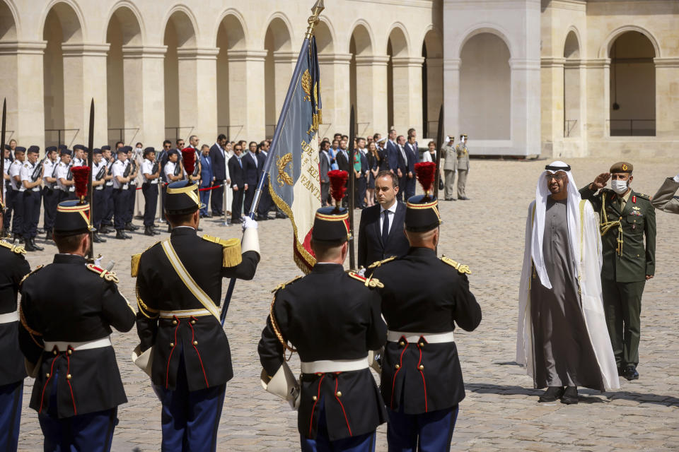 France's Defense Minister Sebastien Lecornu, left, welcome United Arab Emirates' President Sheikh Mohammed Bin Zayed, center during a welcome ceremony at the Invalides monument in Paris, Monday, July 18, 2022. United Arab Emirates' President Sheikh Mohammed Bin Zayed is for a two-days visit in France. (AP Photo/Thomas Padilla, Pool)