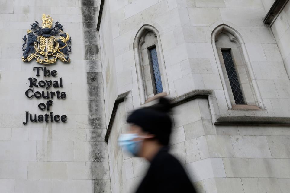 A pedestrian passes by the Royal Courts Of Justice, in London, Jan. 19, 2021.