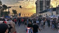 The sun sets over the Iraqi capital while anti-government protesters stage a sit-in on the closed Joumhouriya Bridge that leads to the Green Zone government areas in Baghdad, Iraq, Sunday, Oct. 25, 2020. Thousands of Iraqi protesters have taken to the streets to mark one year since mass anti-government demonstrations swept Baghdad and Iraq's south. Protesters marched Sunday in the capital and several southern cities to renew demands to bring an end to corruption perpetuated by Iraq's politicians. (AP Photo/Qassim Abdul-Zahra)