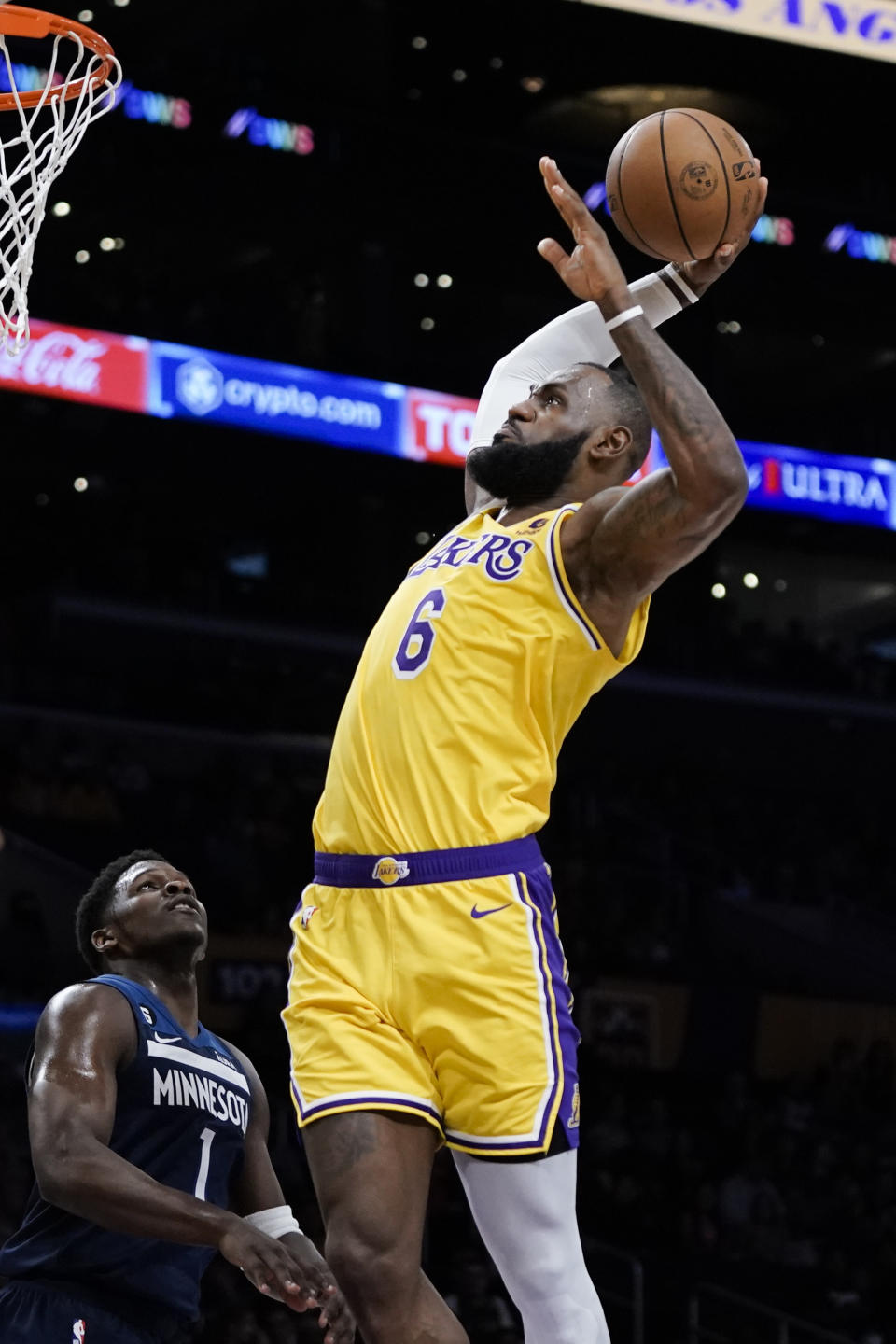 Los Angeles Lakers' LeBron James goes up for a dunk as Minnesota Timberwolves' Anthony Edwards watches during first half of an NBA preseason basketball game Wednesday, Oct. 12, 2022, in Los Angeles. (AP Photo/Jae C. Hong)