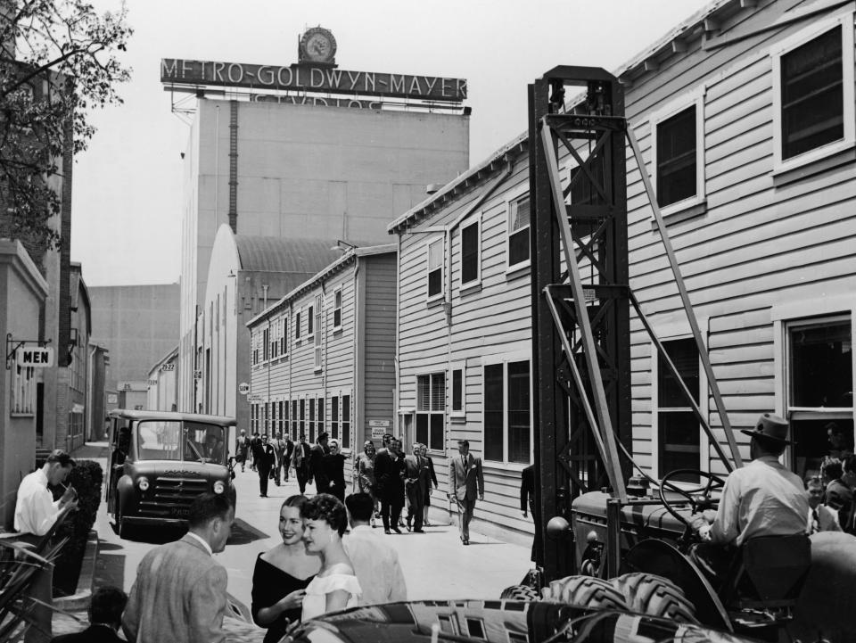 A man moves machinery and sets as groups of people walk down the main thoroughfare of MGM Studios in Hollywood, California, circa 1945 (Hulton Archive/Getty Images)