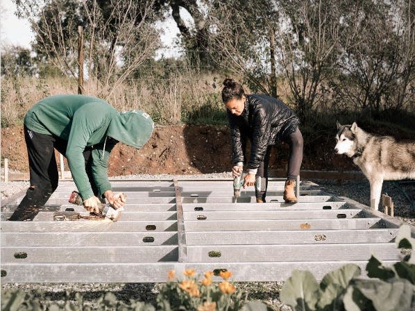 Romero and Diaz working on the metal foundation of the cabin.