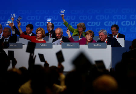 German Chancellor Angela Merkel and delegates vote during a Christian Democratic Union (CDU) party congress in Berlin, Germany, February 26, 2018. REUTERS/Hannibal Hanschke