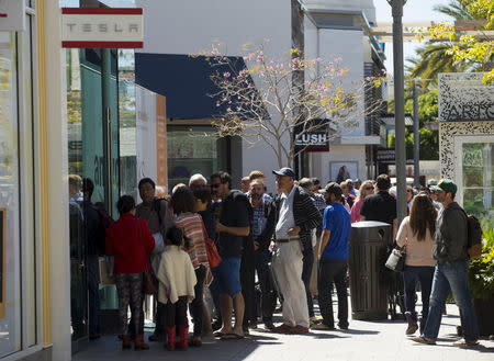 People wait in line at a Tesla Motors dealership to place deposits on the electric car company's mid-priced Model 3 in La Jolla, California, March 31, 2016. REUTERS/Mike Blake