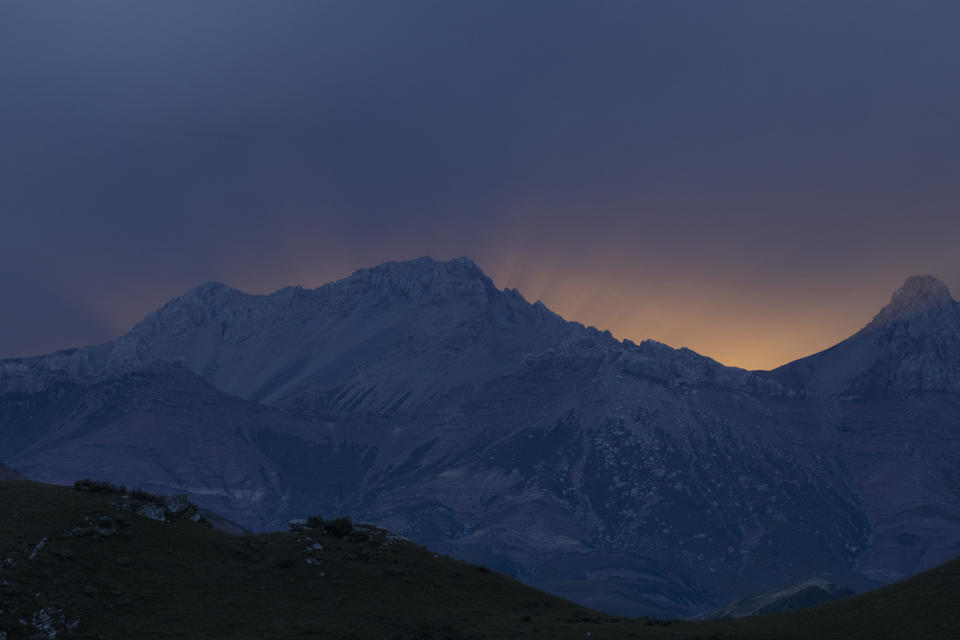 A sunset casts rays of light over the top of a mountain range in Angsai, an area inside the Sanjiangyuan region in western China's Qinghai province on Monday, Aug. 26, 2019. “This is one of the most special regions in China, in the world,” says Lu Zhi, a Peking University conservation biologist who has worked in Qinghai for two decades. (AP Photo/Ng Han Guan)