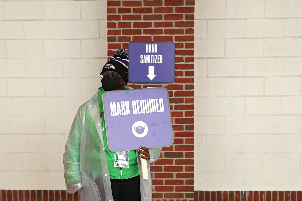 An employee holds a sign that says "Mask Required" at M&T Bank Stadium in Baltimore, Maryland, Nov. 1, 2020. The Ravens are dealing with a COVID-19 outbreak that could threaten their season. (Patrick Smith/Getty Images)