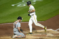 Pittsburgh Pirates' Bryan Reynolds, right, crosses home plate past Detroit Tigers catcher Jake Rogers after hitting a solo home run off relief pitcher Tyler Holton during the sixth inning of a baseball game in Pittsburgh, Monday, April 8, 2024. (AP Photo/Gene J. Puskar)