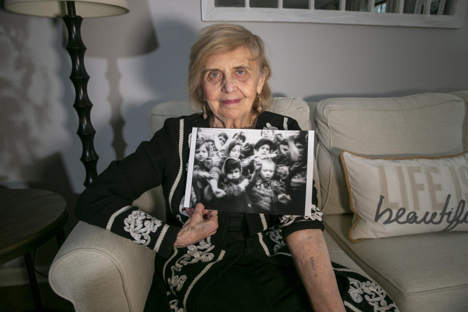 In Morristown, New Jersey, on Monday, March 13, 2023, Holocaust survivor Tova Friedman, 85, holds out her left arm to show the number the Nazis tattooed while holding a photo of her as a six-year-old on the left in the picture, holding out the same arm to show the tattoo to the camera in 1945 after the Soviet military liberated Auschwitz concentration camp. To combat anti-semitism, Friedman's grandson, 17-year-old Aron Goodman, records TikTok videos of her describing the Holocaust that have millions of views on the social media platform. (AP Photo/Ted Shaffrey)