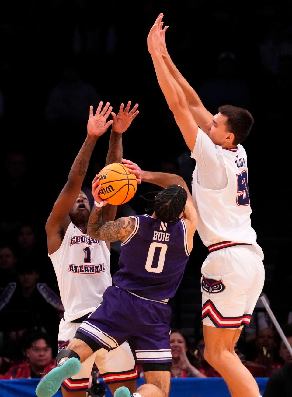 March 22, 2024, Brooklyn, NY, USA; Northwestern Wildcats guard Boo Buie (0) shoots against Florida Atlantic Owls center Vladislav Goldin (50) and Florida Atlantic Owls guard Johnell Davis (1) in the first round of the 2024 NCAA Tournament at the Barclays Center. Mandatory Credit: Robert Deutsch-USA TODAY Sports