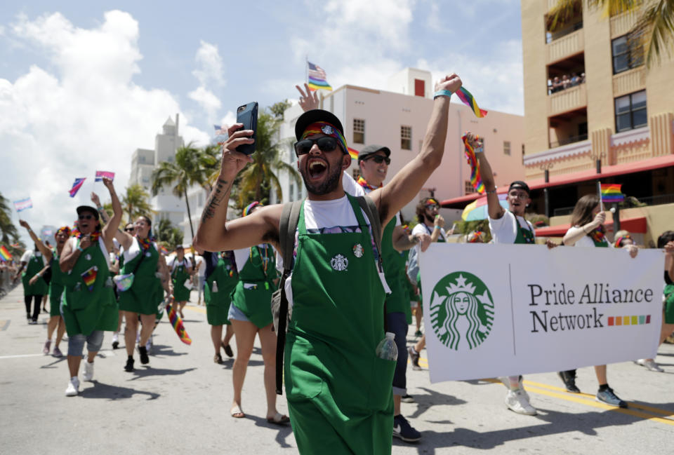 In this April 7, 2019, photo, people with the Pride Alliance Network, sponsored by Starbucks, walk along Ocean Drive, during the 11th annual Pride Parade, as part of Miami Beach Pride week, in Miami Beach, Fla. Florida is now home to two metro areas with among the highest concentrations of gay and lesbian coupled households in the U.S., according to a new report released by the U.S. Census Bureau. Orlando and Miami had the fourth and sixth highest concentrations of same sex coupled households in the U.S. (AP Photo/Lynne Sladky)