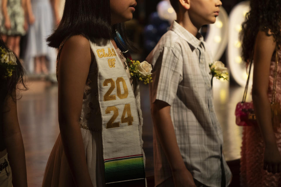 Students sing the national anthem during a graduation ceremony at Trevor Day School, Friday, June 21, 2024 in New York. Thousands of migrant families in New York City are facing a summer of uncertainty for their school-aged children with a citywide limit of 60 days in a shelter before needing to reapply or find their own. (AP Photo/Jeenah Moon)
