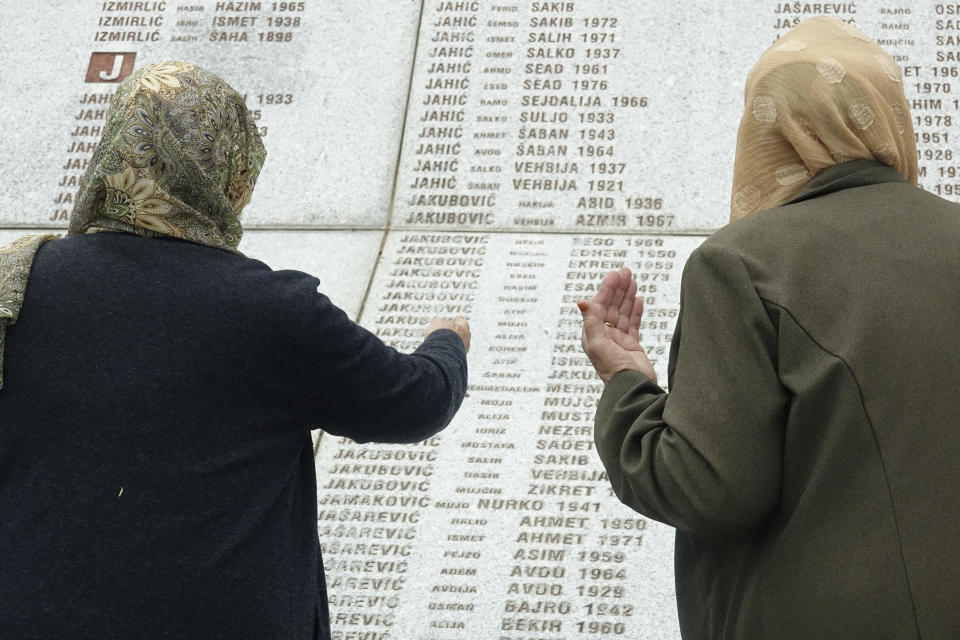 Women who lost their relatives in Srebrenica massacre looks at names at the memorial cemetery in Potocari near Srebrenica, Bosnia, Friday, May 28, 2021. U.N. judges on Tuesday, June 8 deliver their final ruling on the conviction of former Bosnian Serb army chief Radko Mladic on charges of genocide, war crimes and crimes against humanity during Bosnia’s 1992-95 ethnic carnage. Nearly three decades after the end of Europe’s worst conflict since World War II that killed more than 100,000 people, a U.N. court is set to close the case of the Bosnian War’s most notorious figure. (AP Photo/Eldar Emric)