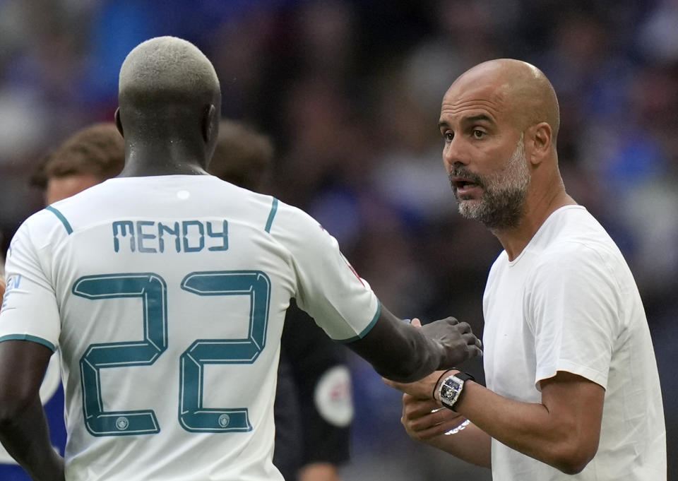 El técnico del Manchester City Pep Guardiola (derecha) da instrucciones a Benjamin Mendy durante el partido del Community Shield contra Leicester City en el estadio Wembley, el sábado 7 de agosto de 2021. (AP Foto/Alastair Grant)