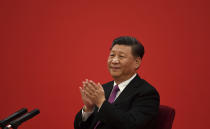 China's President Xi Jinping claps as he listens to Russian President Vladimir Putin via a video link, from the Great Hall of the People in Beijing, Monday, Dec. 2, 2019. (Noel Celis/Pool Photo via AP)