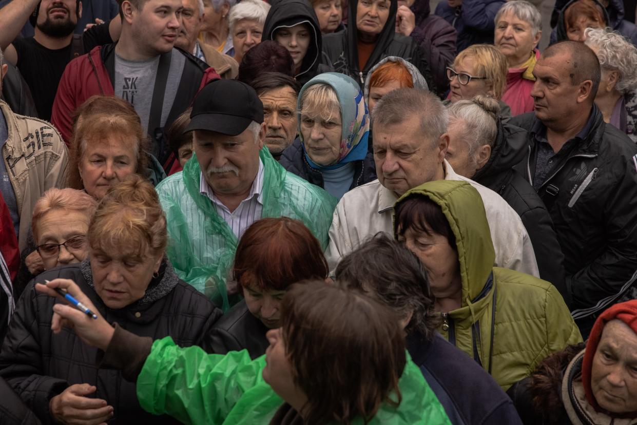 Residents receive humanitarian aid provided by volunteers from Global Empowerment Mission on Sunday in Kherson, Ukraine (Getty Images)