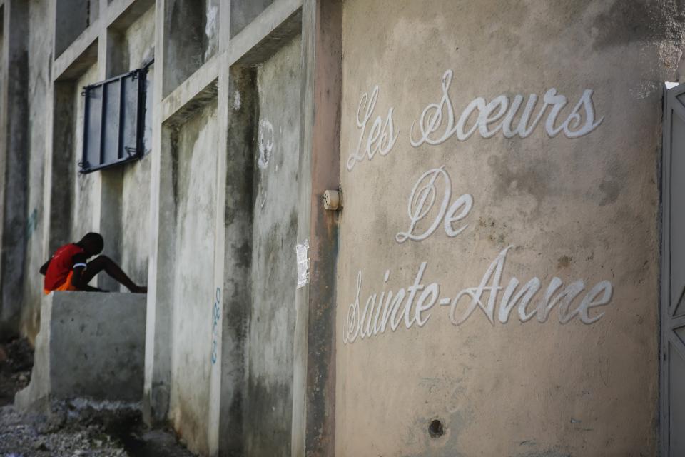 A young boy rests in front of the entrance of the Sisters of Saint-Anne residence in Port-au-Prince, Haiti, Monday, Jan. 22, 2024. The Archdiocese of Port-au-Prince is pleading for the release of six nuns from the congregation who were kidnapped last week and demanding that Haiti's government crack down on gang violence. (AP Photo/Odelyn Joseph)