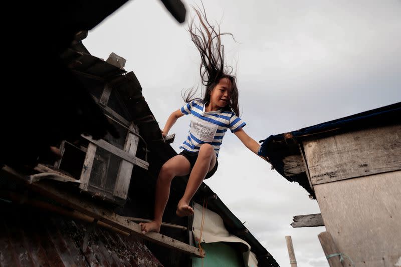 The Wider Image: Rising seas threaten early end for sinking village in Philippines