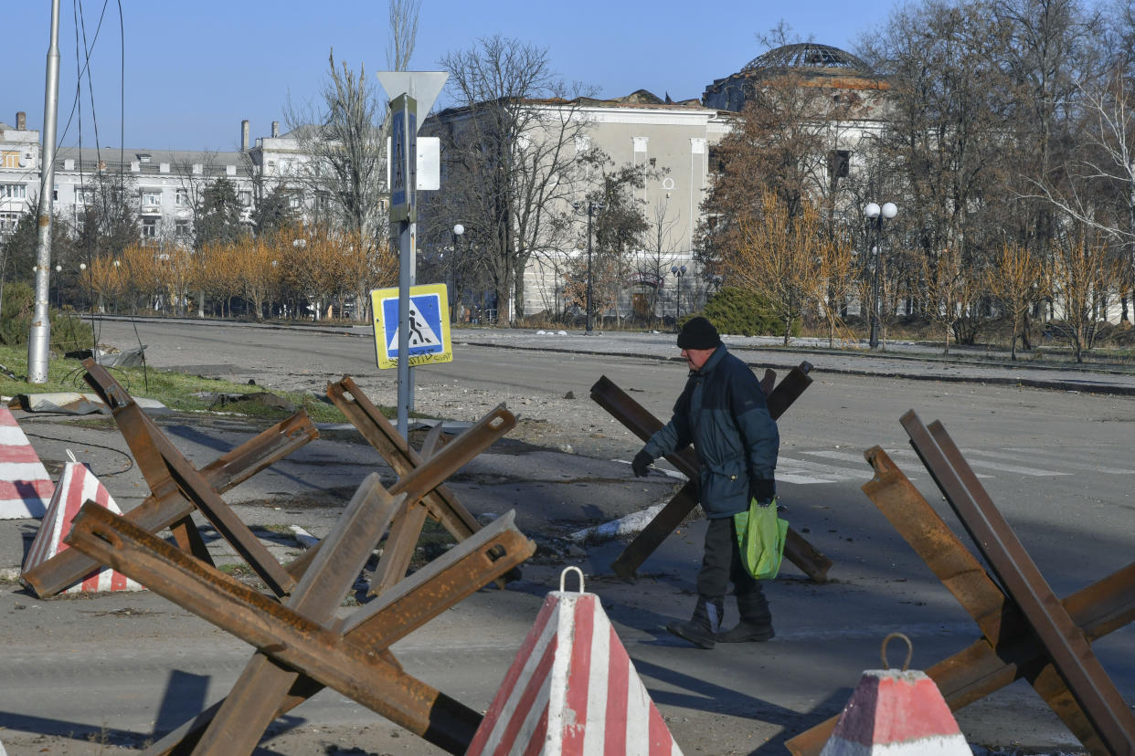 A local resident walks along a street in the area of the heaviest battles with the Russian invaders in Bakhmut, Ukraine, Tuesday, Dec. 20, 2022. (AP Photo/Andriy Andriyenko)