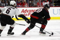 Carolina Hurricanes' Sebastian Aho (20) has the puck tipped away by Arizona Coyotes' Jakob Chychrun (6) during the second period of an NHL hockey game in Raleigh, N.C., Sunday, Oct. 31, 2021. (AP Photo/Karl B DeBlaker)