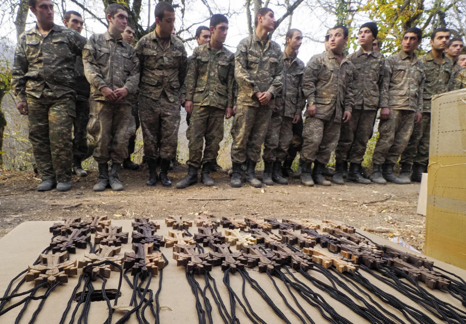 Ethnic Armenian soldiers stand prior to a baptism ceremony in a military camp near the front line during a military conflict in separatist region of Nagorno-Karabakh, Monday, Nov. 2, 2020. Fighting over the separatist territory of Nagorno-Karabakh entered sixth week on Sunday, with Armenian and Azerbaijani forces blaming each other for new attacks. (AP Photo)