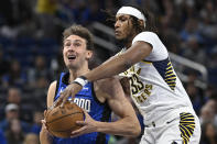 Orlando Magic forward Franz Wagner, left, is fouled by Indiana Pacers center Myles Turner (33) while driving to the basket during the first half of an NBA basketball game, Sunday, March 10, 2024, in Orlando, Fla. (AP Photo/Phelan M. Ebenhack)